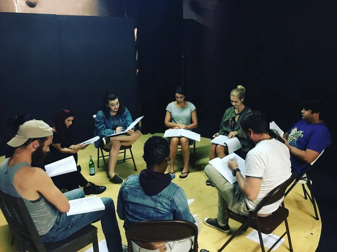 The company of A Piece of My Heart, Sidetracked Creative Artists, in a circle of chairs with scripts, Katie Peabody among them