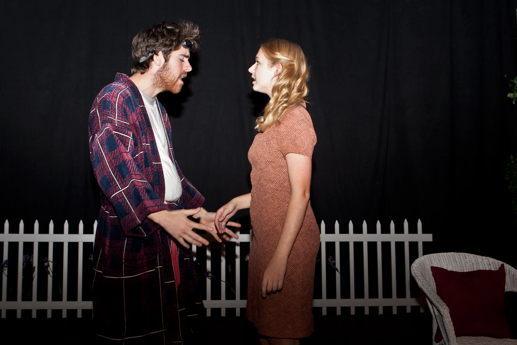 Katie Peabody as Dolly in Bad Habits, 2032 Productions, facing another character beside a white picket fence