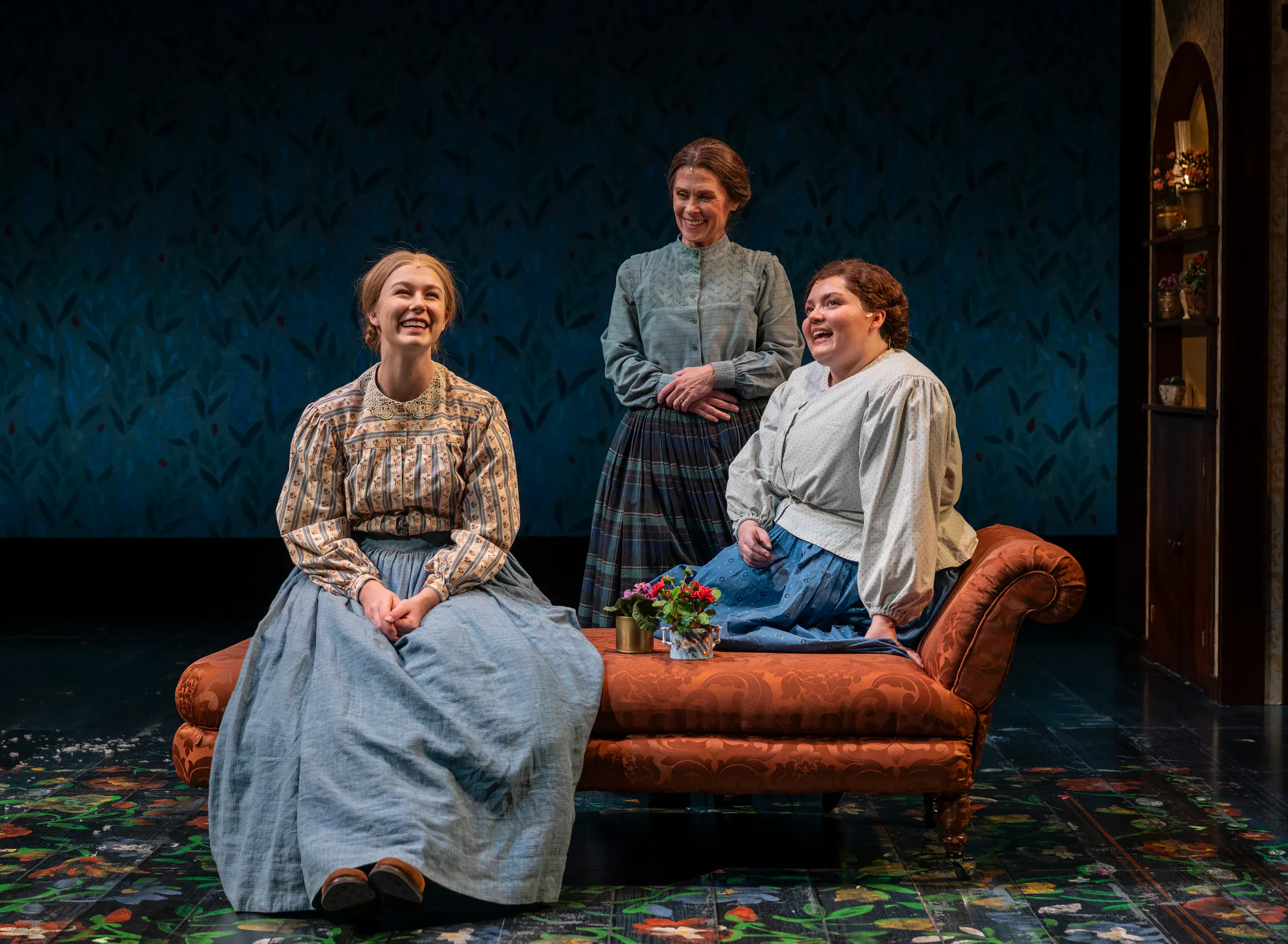 Katie Peabody as Beth March with her sisters on the parlour set of Little Women at Milwaukee Repertory Theater