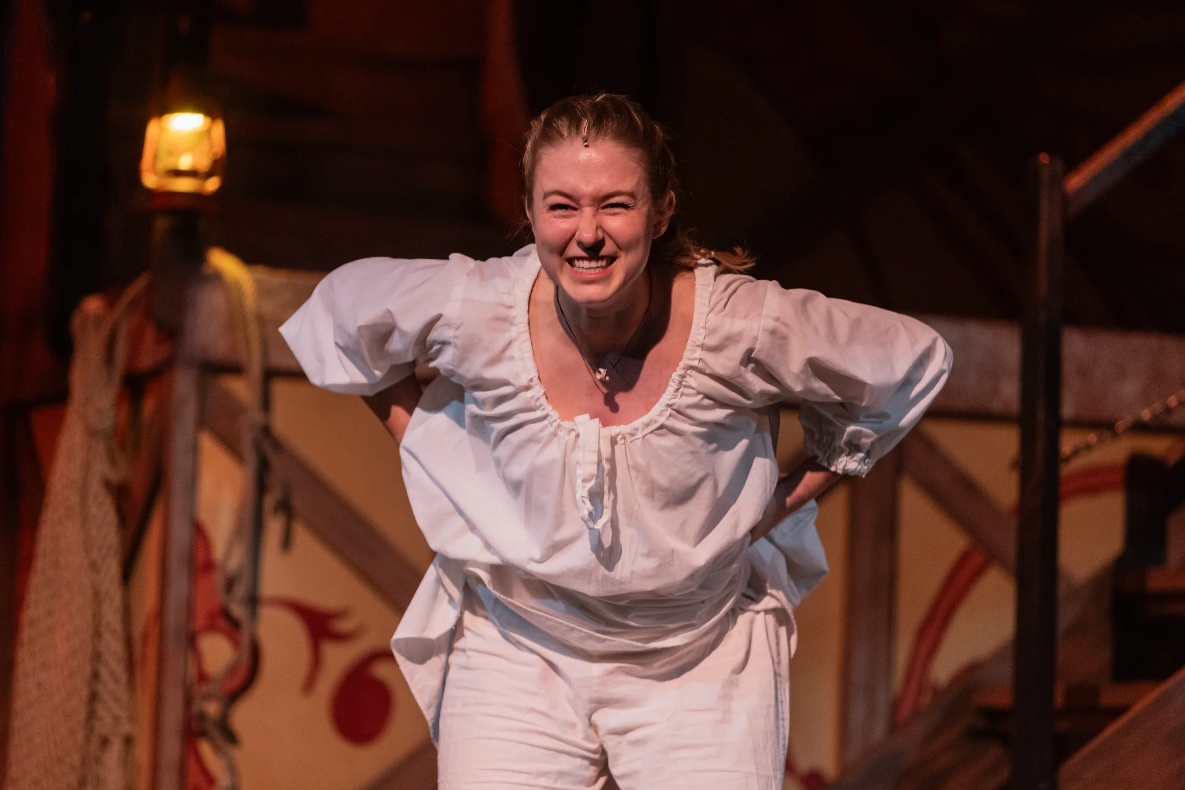 Katie Peabody as Abigail Burgess in Matinicus: A Lighthouse Play, hands on hips, leaning forward and laughing