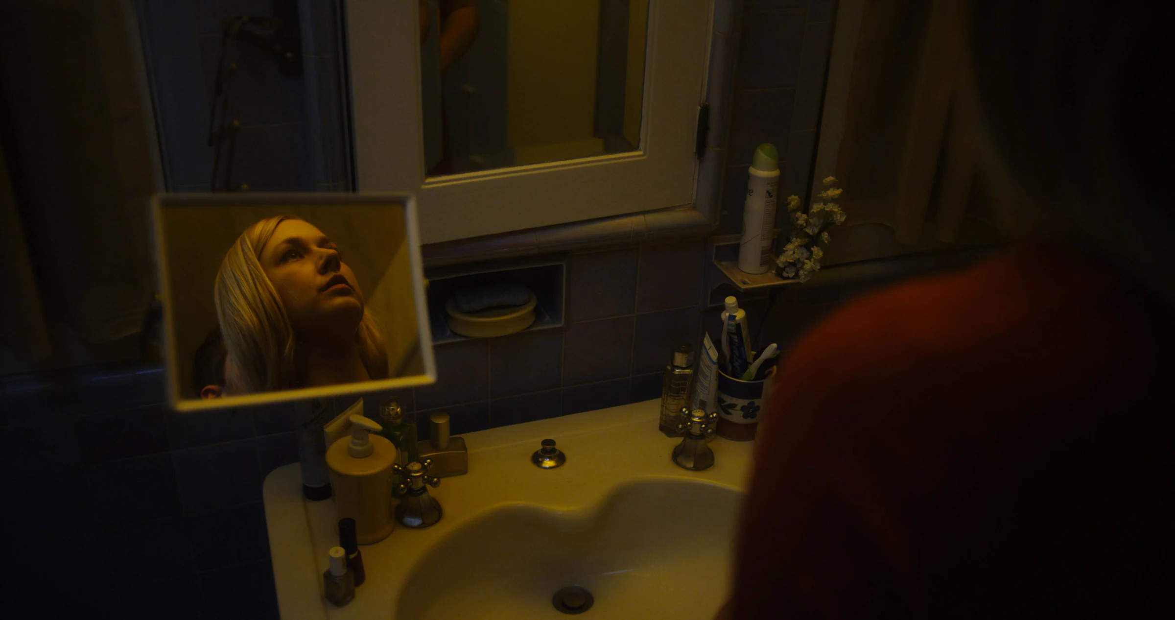 A figure reflected in a bathroom mirror, from the short film Monitor, where Katie Peabody played Macy