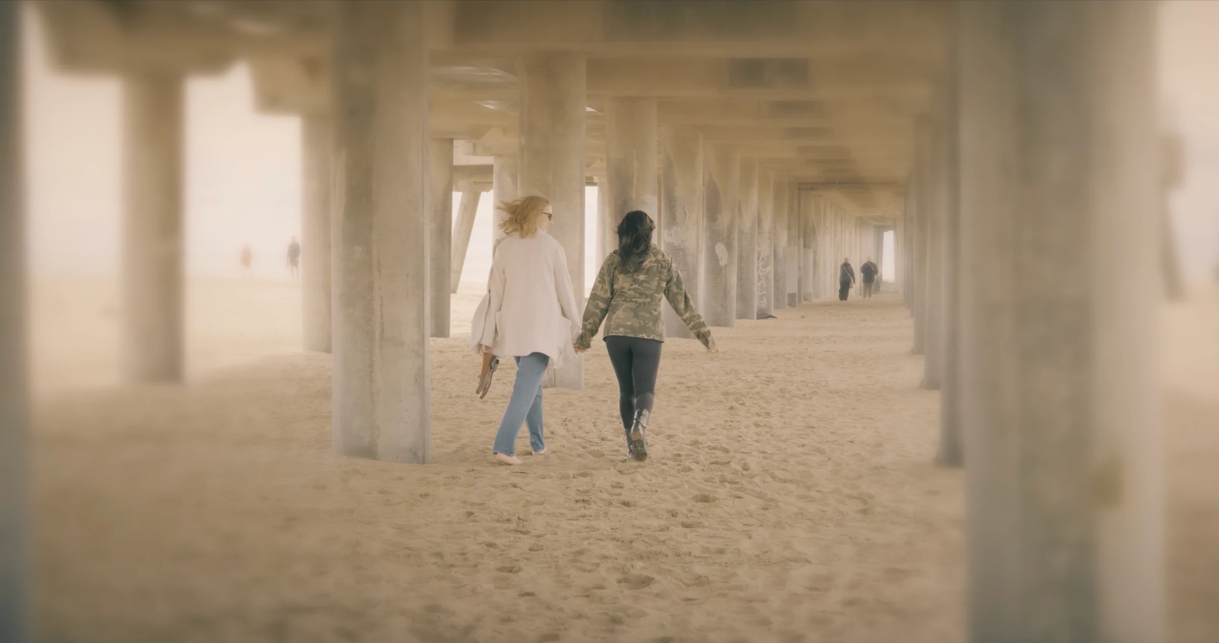 Two figures walking beneath a pier in the short film October's Eyes, where Katie Peabody played April