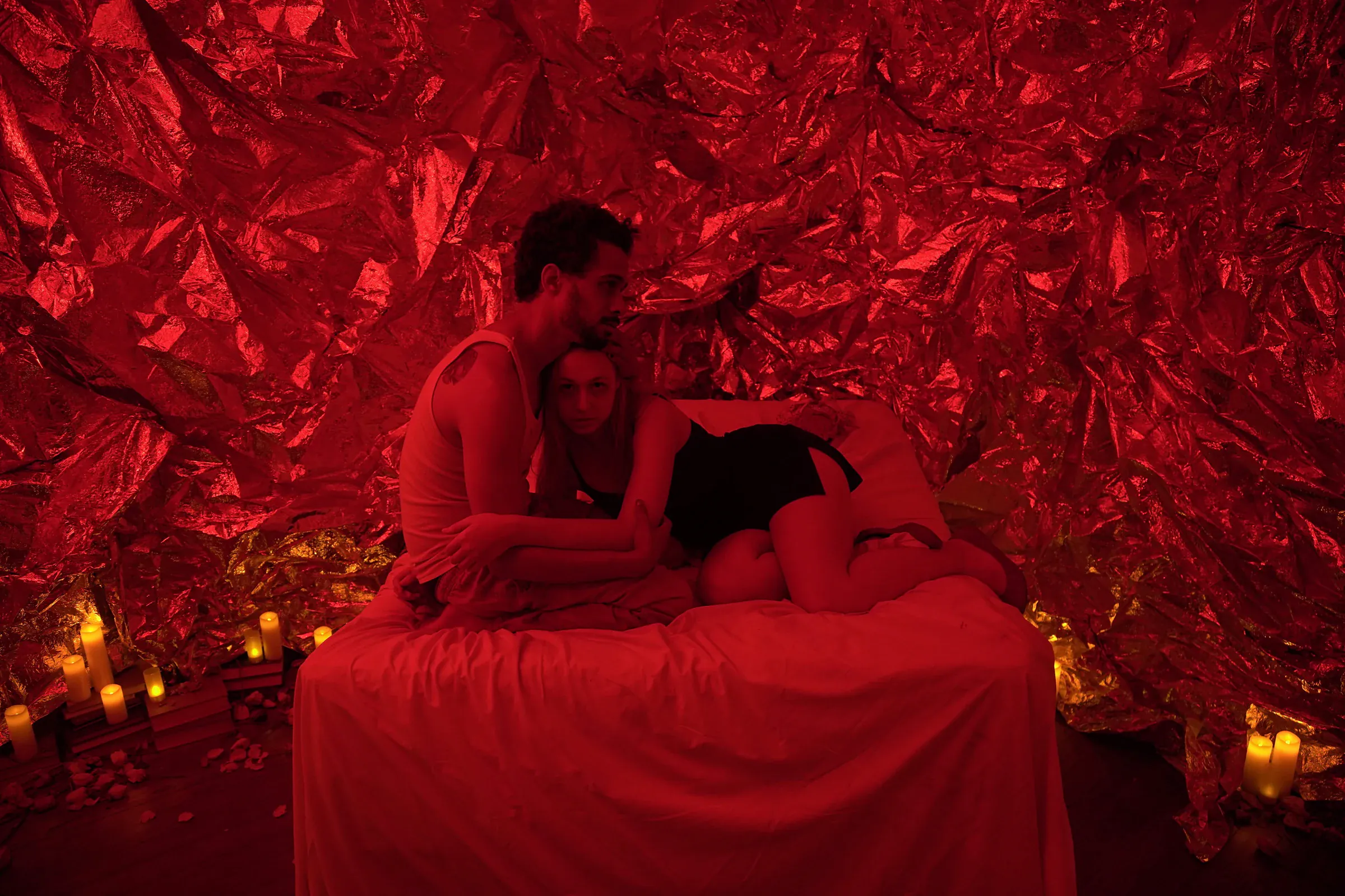 A red-lit room with figures on a bed in The Game, Overlook Film Festival and E3W Productions, where Katie Peabody played Anais Porceau
