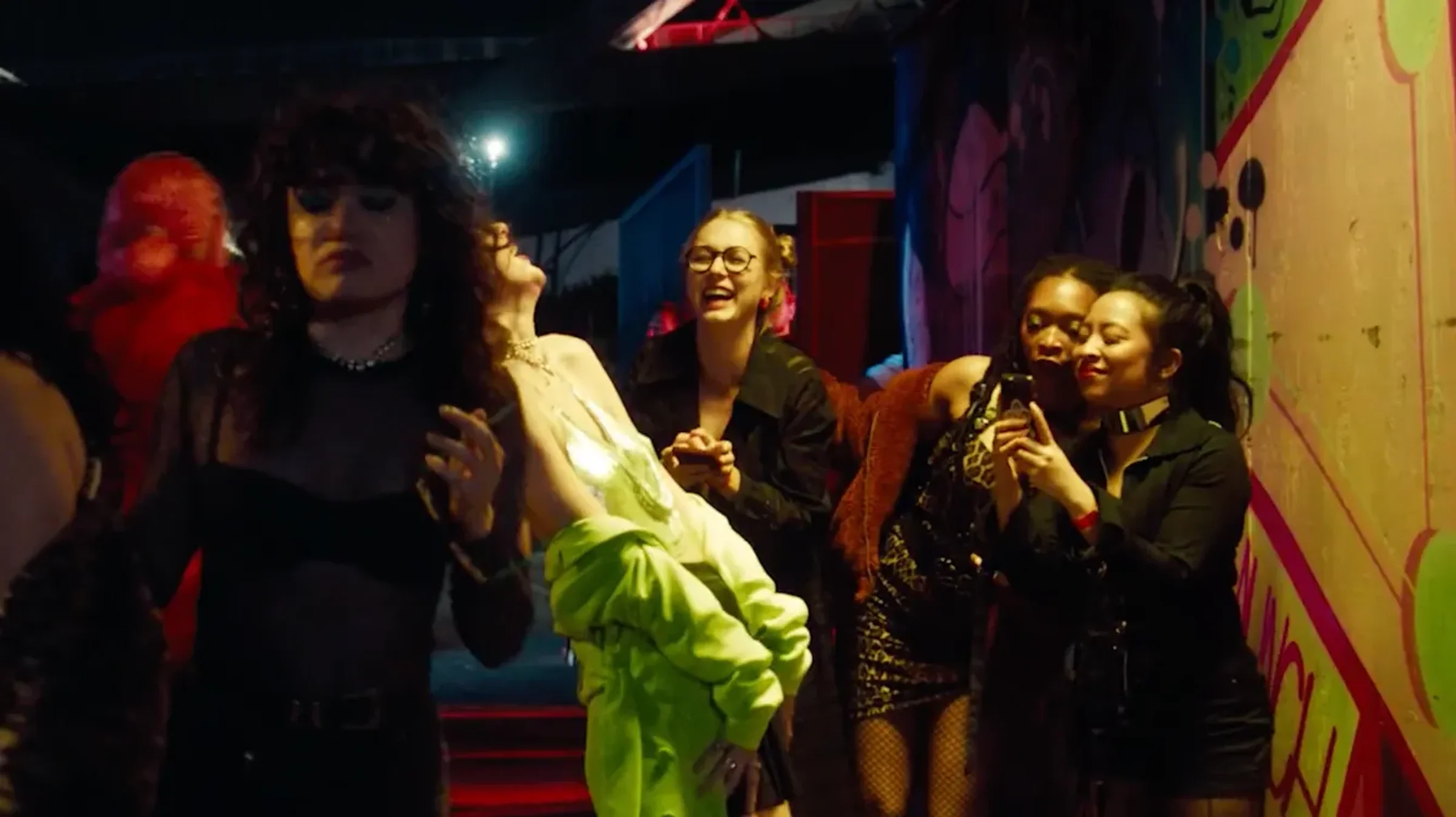 A crowded, brightly lit party scene from the short film Personally I Find It Rude to Be Boring, Katie Peabody among the ensemble